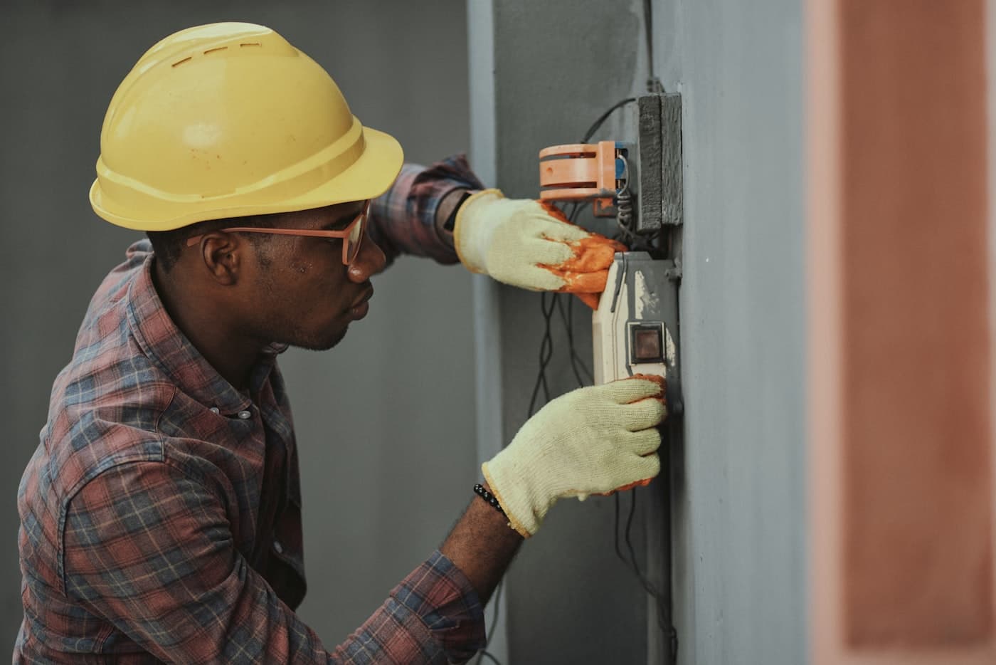 An apprentice electrician wiring an electrical panel on a jobsite